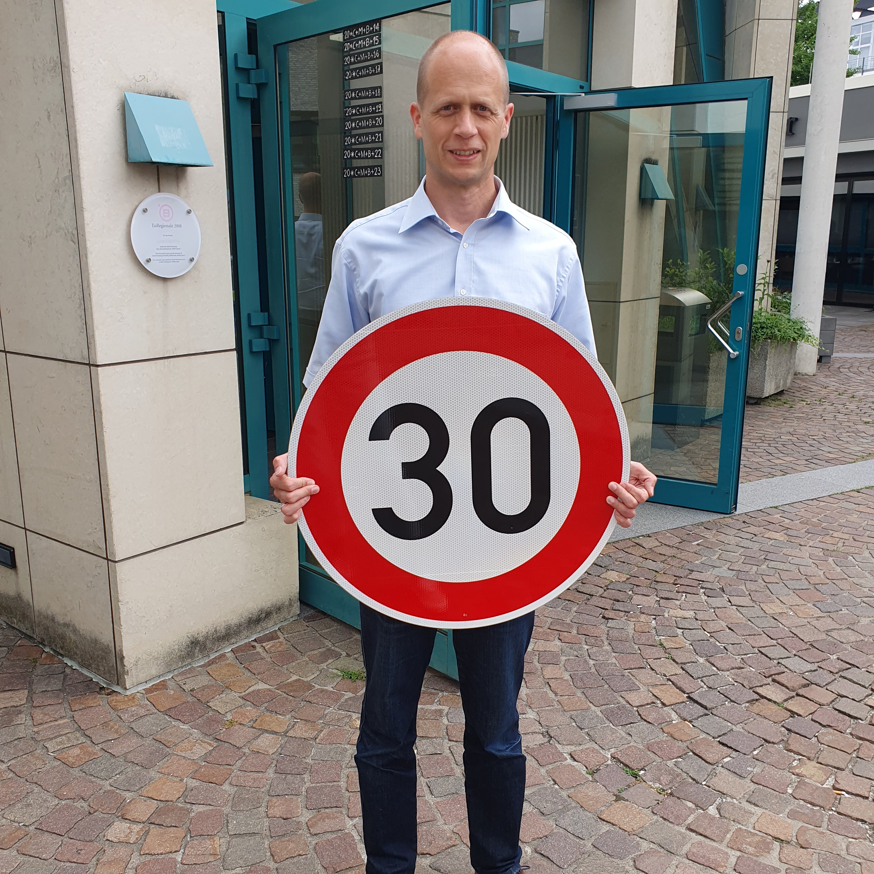 Bürgermeister Kai Louis mit einem Verkehrsschild Tempo 30