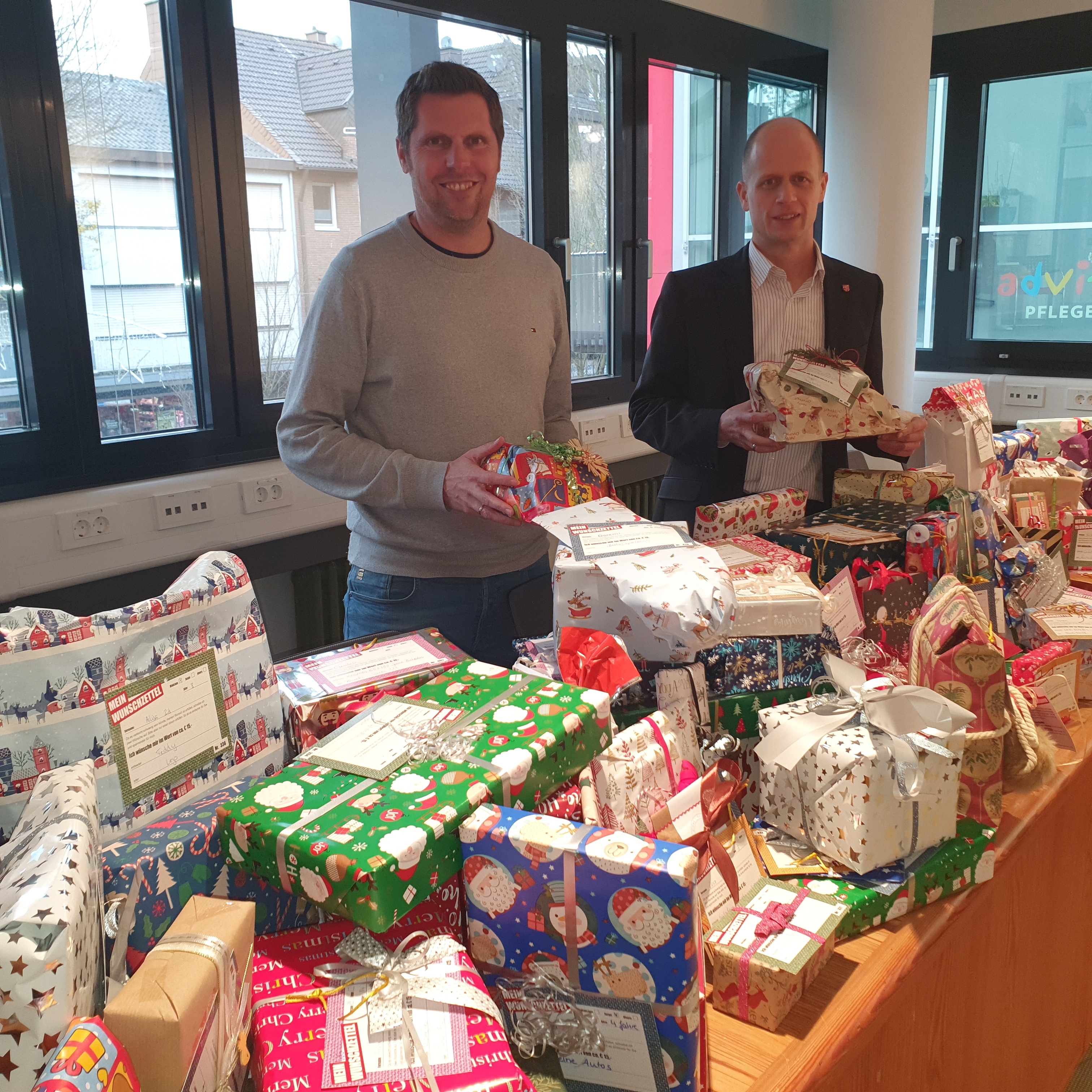 Bürgermeister Kai Louis und Holger Louis, Wirtschaftsförderung, freuen sich über die liebevoll verpackten Geschenke zu Weihnachten