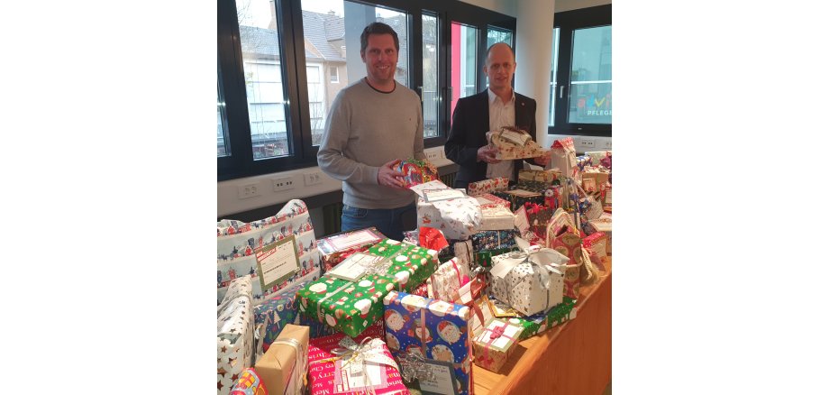 Bürgermeister Kai Louis und Holger Louis, Wirtschaftsförderung, freuen sich über die liebevoll verpackten Geschenke zu Weihnachten