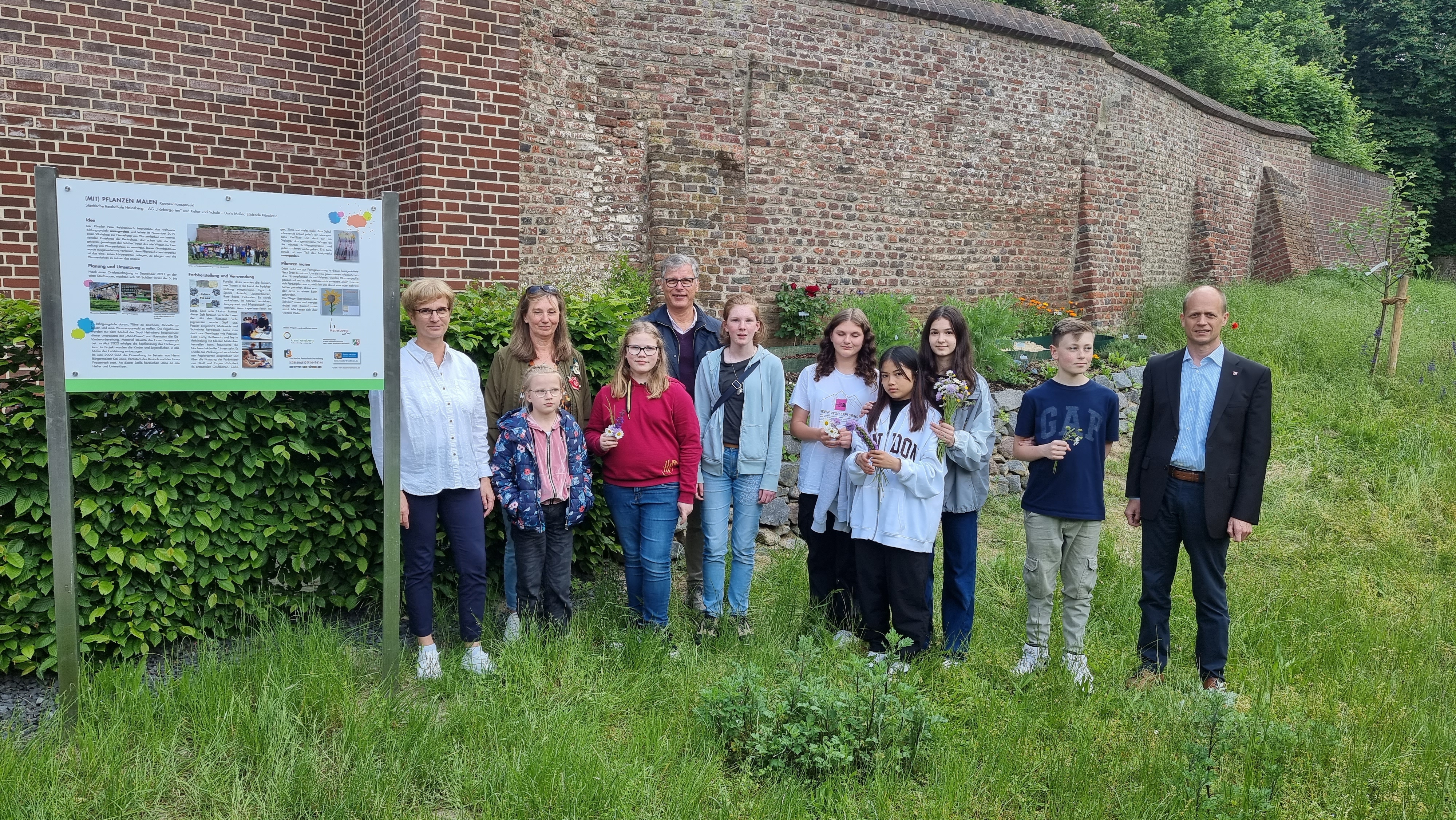 Bürgermeister Kai Louis freut sich mit Schülerinnen und Schülern über die Erweiterung des Färbergartens