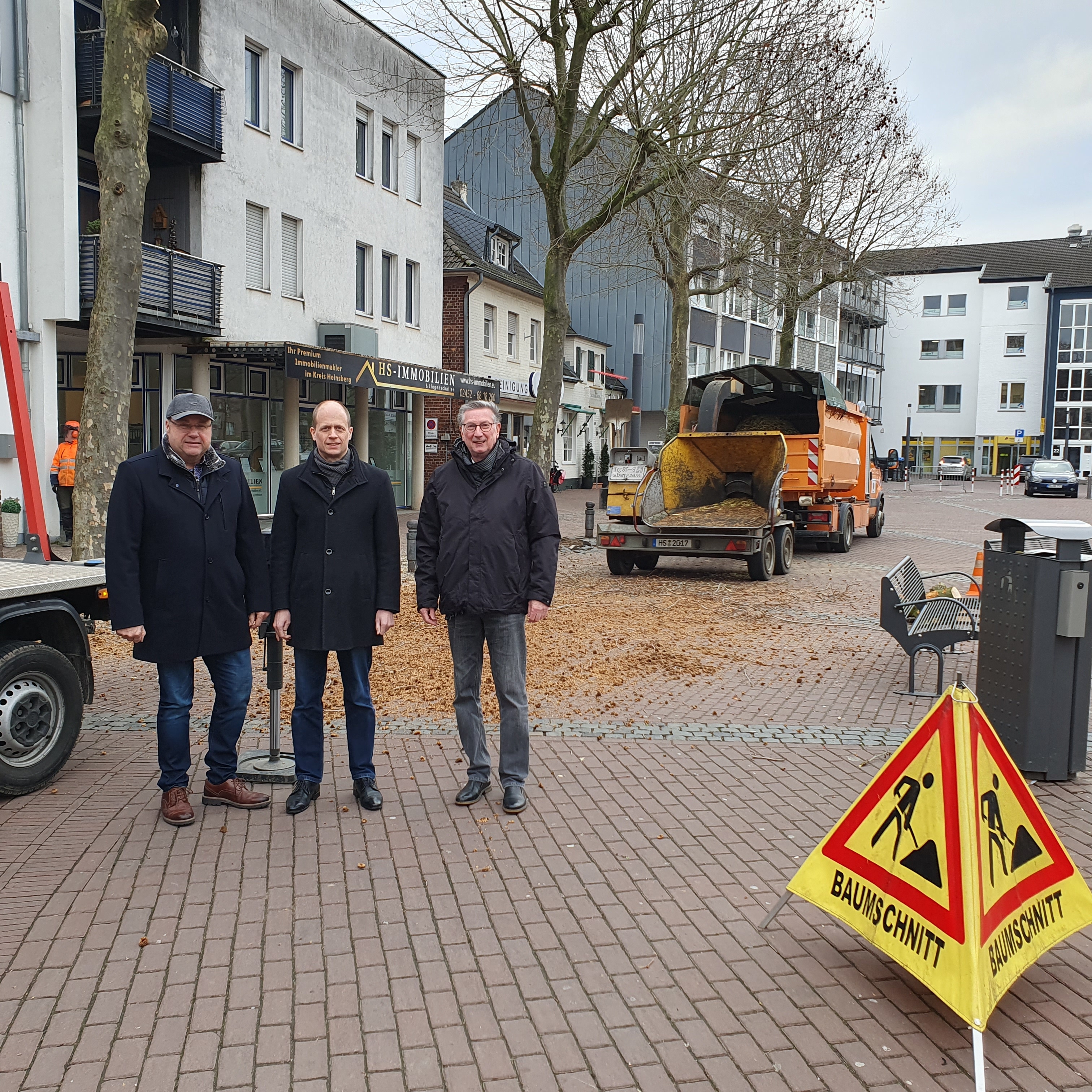 Norbert Cox, Leiter des Amtes für Stadtgrün und Baubetrieb, Bürgermeister Kai Louis und Ortsvorsteher Siggi Jansen machen sich ein Bild von den Baumpflegearbeiten auf dem Heinsberger Marktplatz