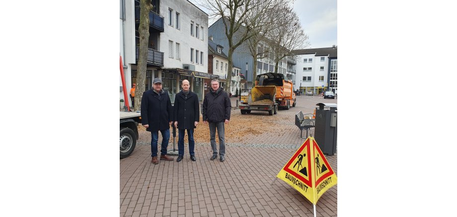 Norbert Cox, Leiter des Amtes für Stadtgrün und Baubetrieb, Bürgermeister Kai Louis und Ortsvorsteher Siggi Jansen machen sich ein Bild von den Baumpflegearbeiten auf dem Heinsberger Marktplatz