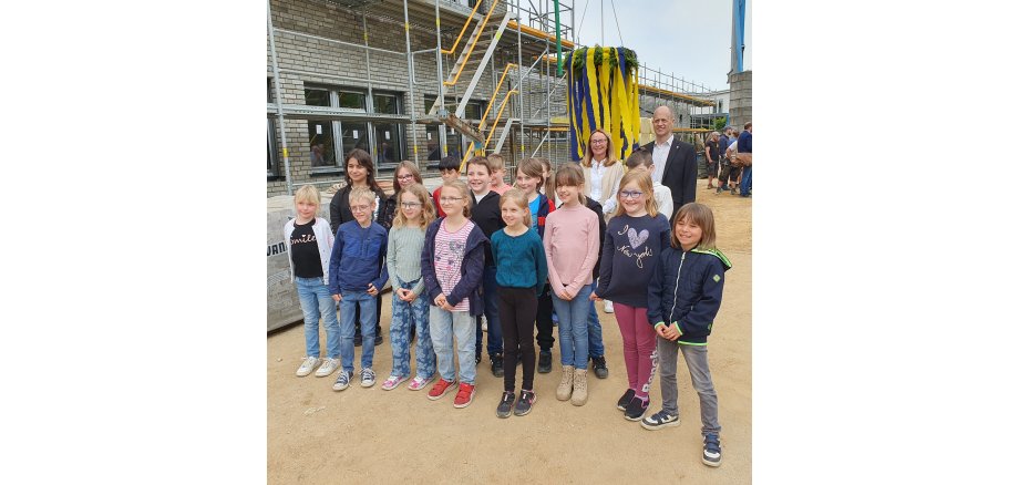 Bürgermeister Kai Louis und Schulleiterin Marlis Minkenberg freuen sich mit Schülern der Marienschule über den Baufortschritt
