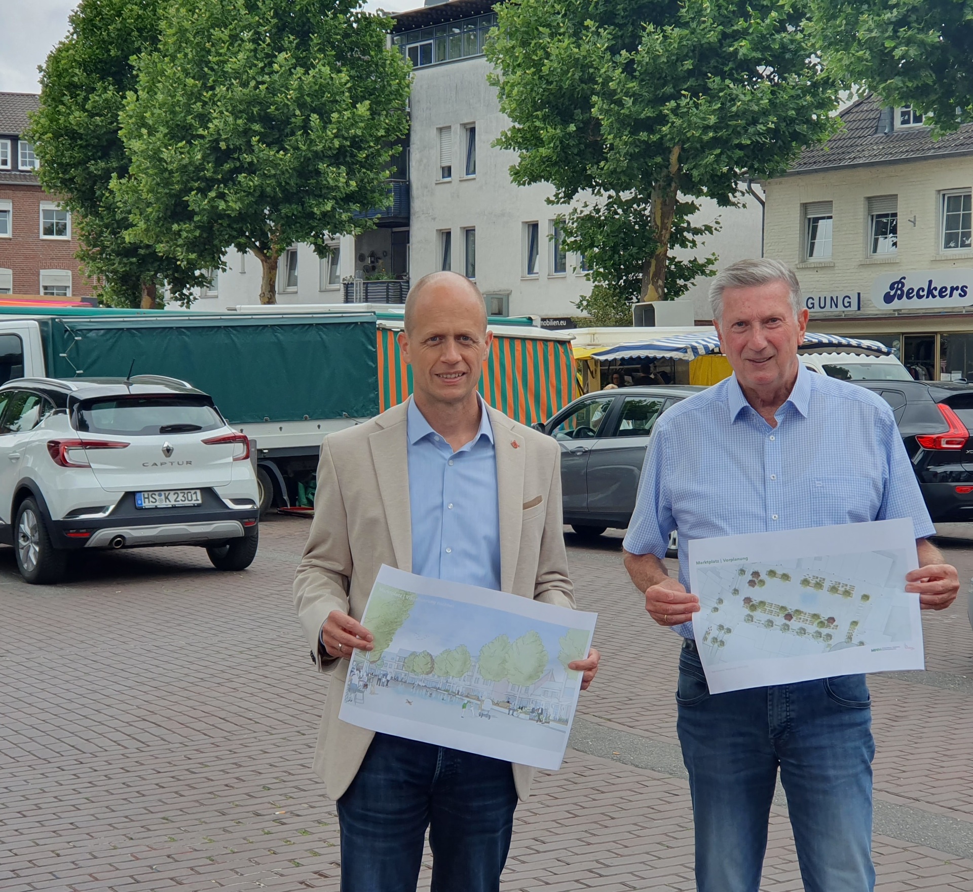 Bürgermeister Kai Louis und Siegfried Jansen, Ortsvorsteher Heinsberg, mit Entwürfen eines neugestalteten Marktplatzes