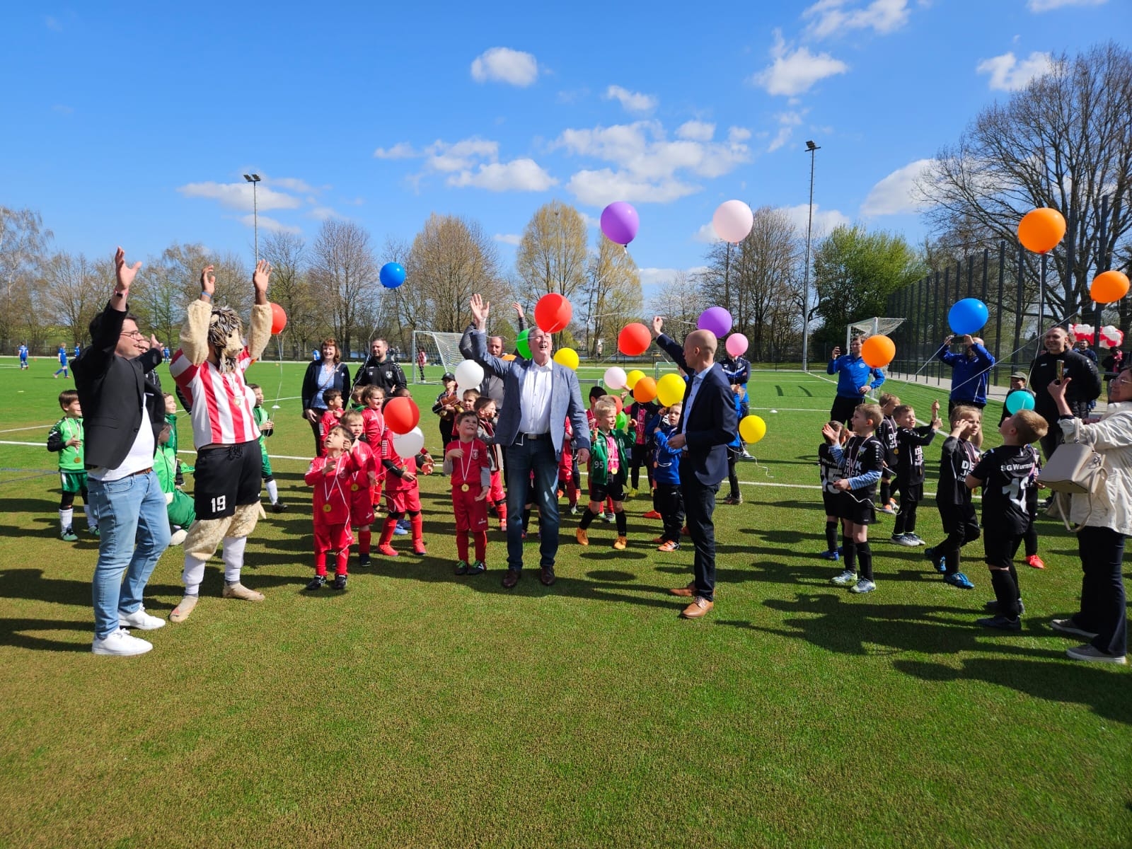 Bildunterschrift: Bei strahlendem Sonnenschein ließ Bürgermeister Kai Louis (Mitte r.) gemeinsam mit alles Sportbegeisterten bunte Luftballons steigen
