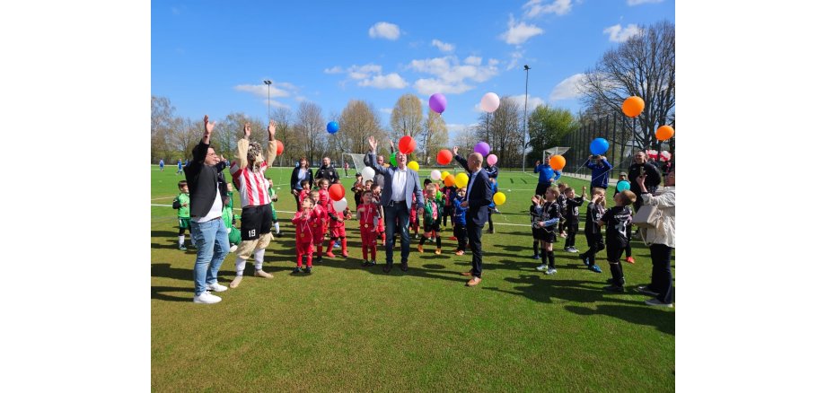 Bildunterschrift: Bei strahlendem Sonnenschein ließ Bürgermeister Kai Louis (Mitte r.) gemeinsam mit alles Sportbegeisterten bunte Luftballons steigen