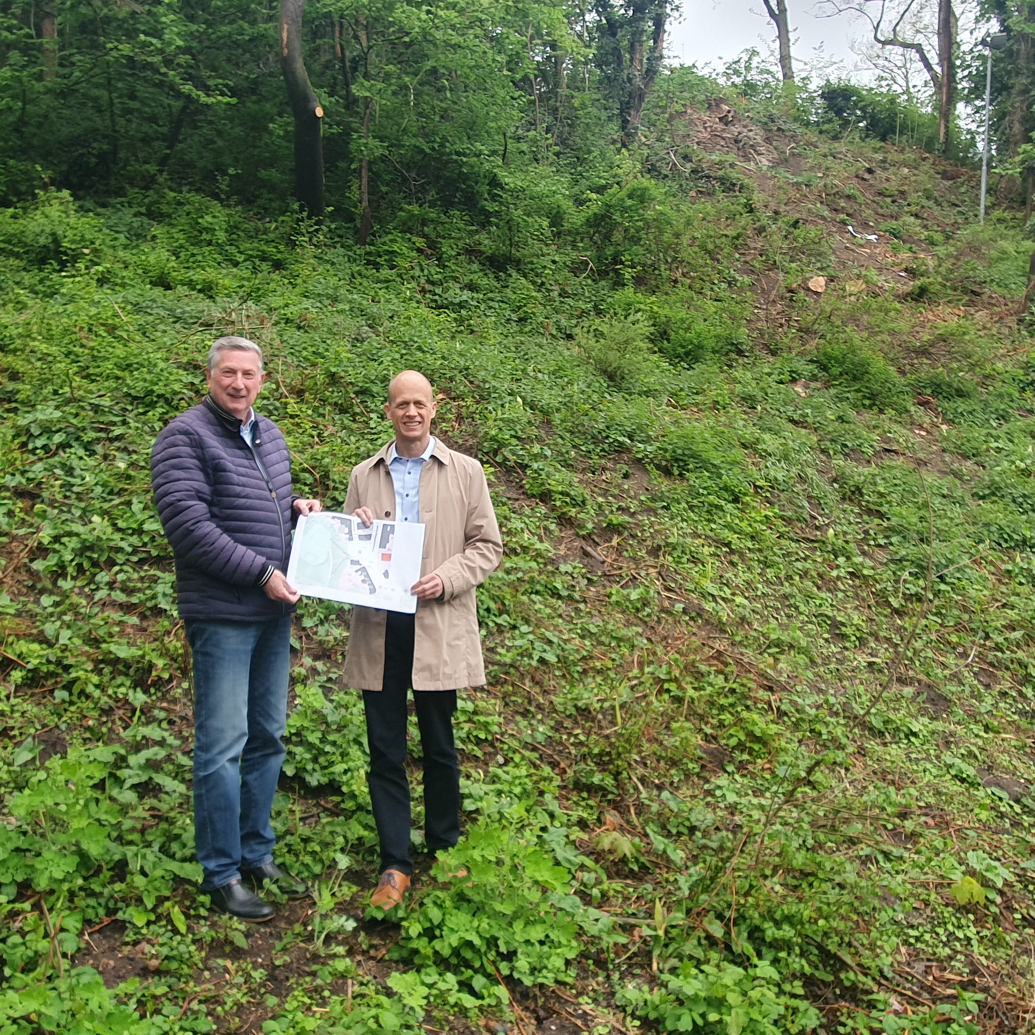 Bürgermeister Kai Louis und Ortsvorsteher Siegfried Jansen am Hang des Burgbergs: an dieser Stelle wird die neue Fluchttreppe gebaut